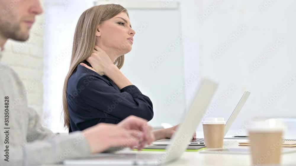 Creative Woman working on Laptop and having Neck Pain in Office Creative Woman working on Laptop and having Neck Pain in Office