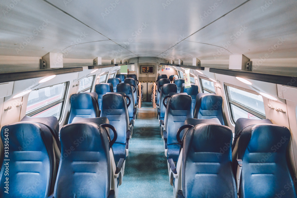 Interior of railway passenger car of the second class in train in Lombardy in Italy. Train interior. Blue seats in a commuter train. Interior of an Italian railway carriage. Empty without people Interior of railway passenger car of the second class in train in Lombardy in Italy. Train interior. Blue seats in a commuter train. Interior of an Italian railway carriage. Empty without people