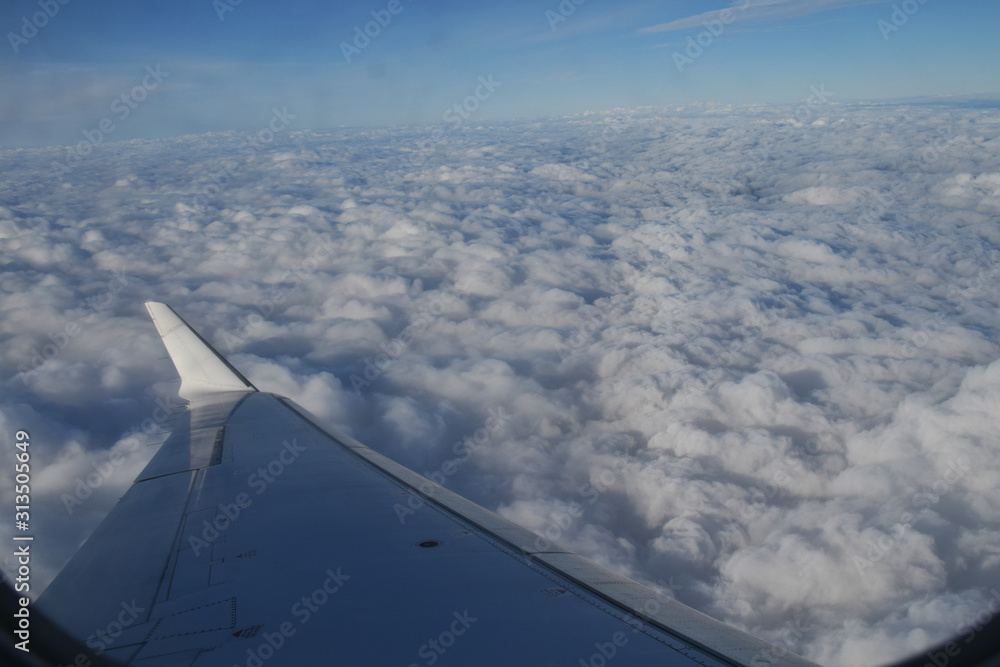 Nuages et aile d'avion vus en plein vol par le hublot