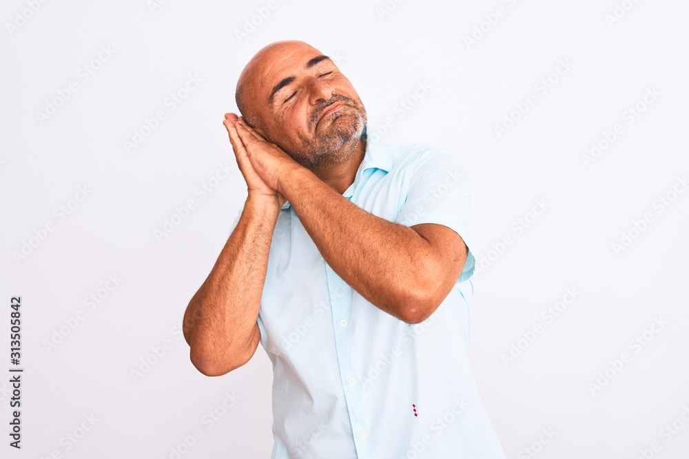 Middle age handsome man wearing casual shirt standing over isolated white background sleeping tired dreaming and posing with hands together while smiling with closed eyes. Middle age handsome man wearing casual shirt standing over isolated white background sleeping tired dreaming and posing with hands together while smiling with closed eyes.