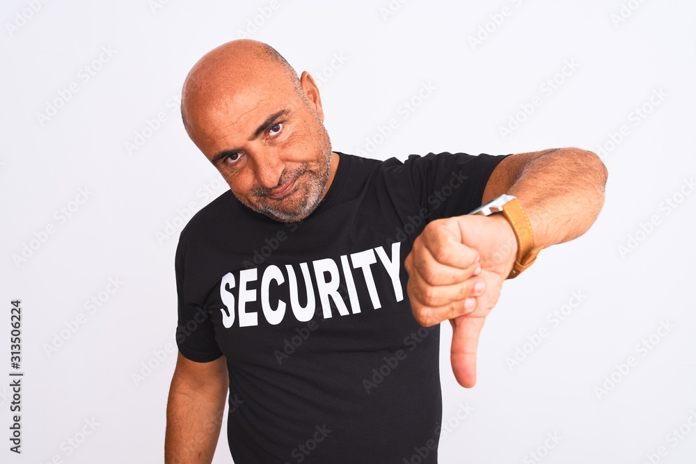 Middle age safeguard man wearing security uniform standing over isolated white background looking unhappy and angry showing rejection and negative with thumbs down gesture. Bad expression. Middle age safeguard man wearing security uniform standing over isolated white background looking unhappy and angry showing rejection and negative with thumbs down gesture. Bad expression.