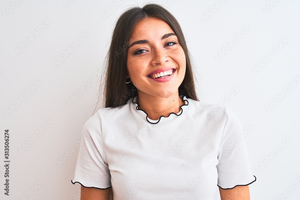Young beautiful woman wearing casual t-shirt standing over isolated white background with a happy face standing and smiling with a confident smile showing teeth Young beautiful woman wearing casual t-shirt standing over isolated white background with a happy face standing and smiling with a confident smile showing teeth
