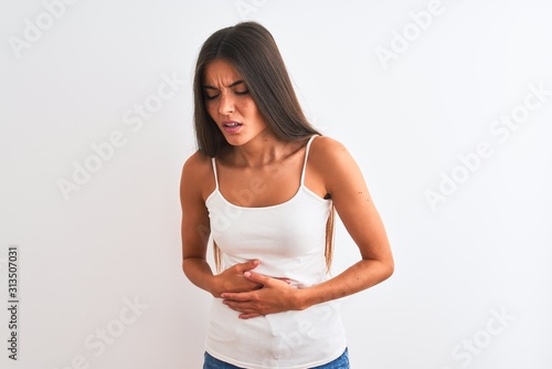 Foto Young beautiful woman wearing casual t-shirt standing over isolated white background with hand on stomach because indigestion, painful illness feeling unwell