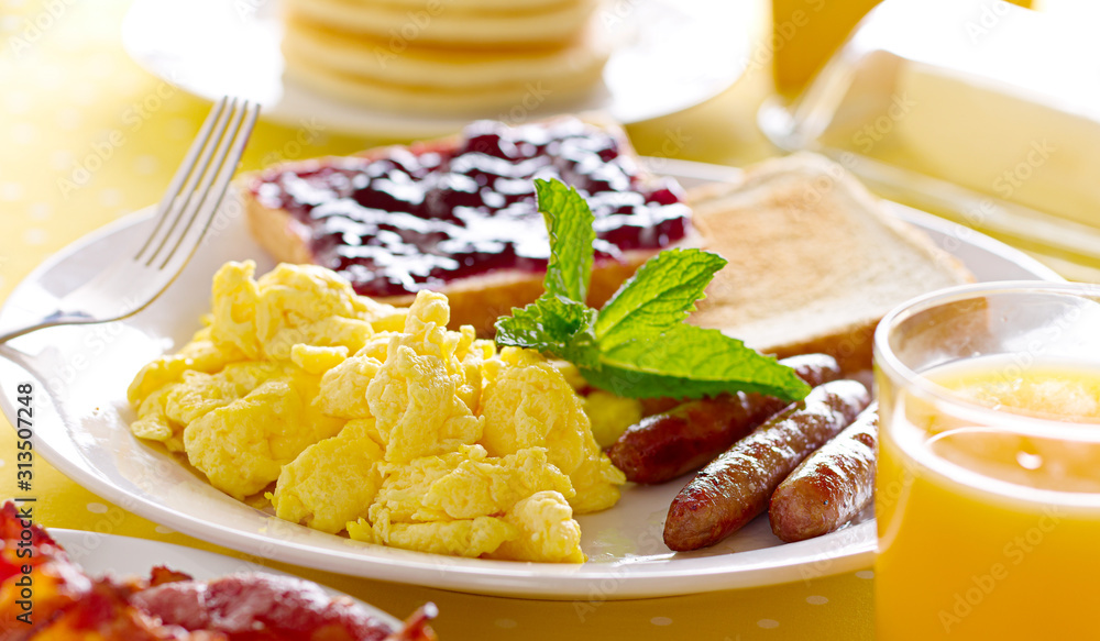 breakfast with scrambled eggs, sausage links and toast. breakfast with scrambled eggs, sausage links and toast.