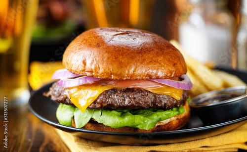 Εκτύπωση καμβά cheeseburger and fries on plate served with beer at restaurant