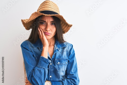 Young beautiful woman wearing denim shirt and hat standing over isolated white background thinking looking tired and bored with depression problems with crossed arms.