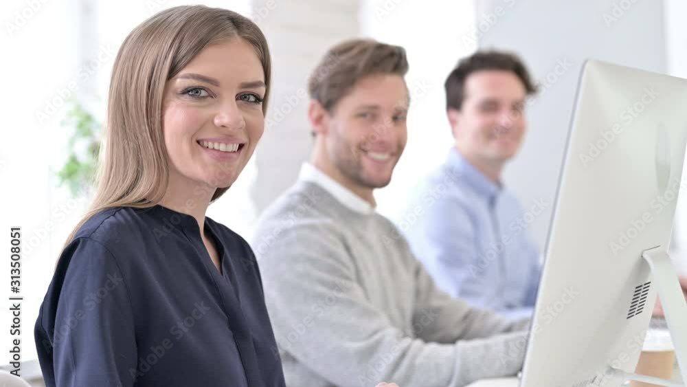 Creative Team using Laptop and Smiling at the Camera Creative Team using Laptop and Smiling at the Camera