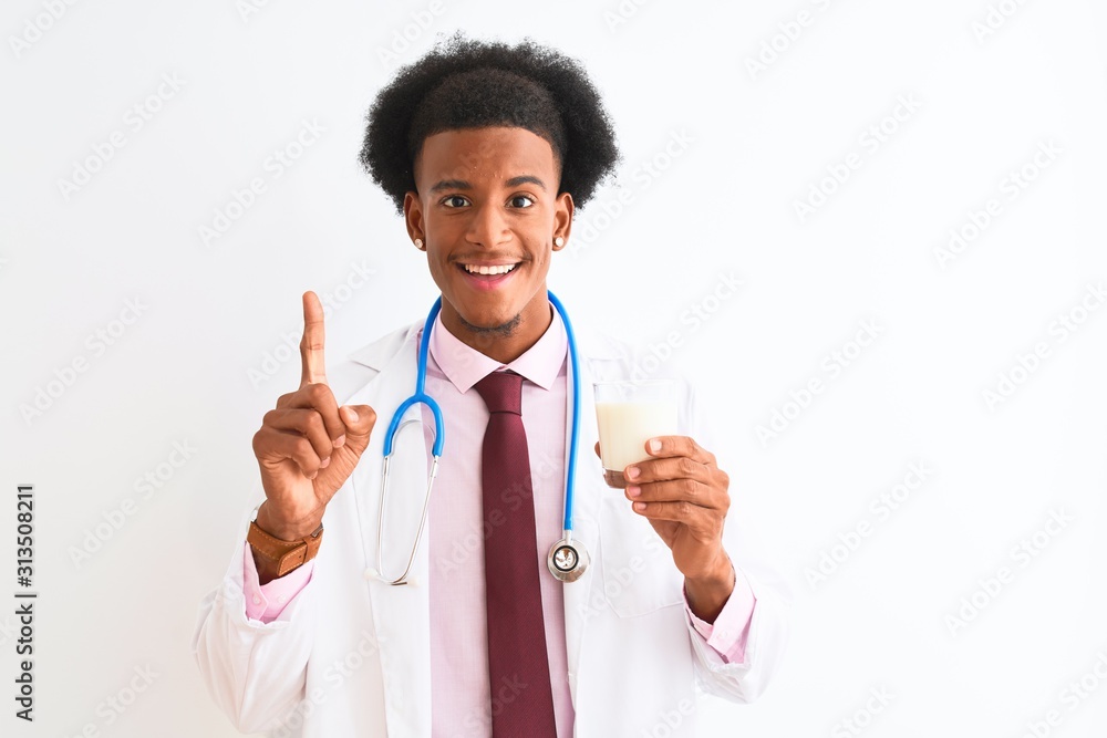 Young african american doctor man drinking glass of milk over isolated white background surprised with an idea or question pointing finger with happy face, number one Young african american doctor man drinking glass of milk over isolated white background surprised with an idea or question pointing finger with happy face, number one
