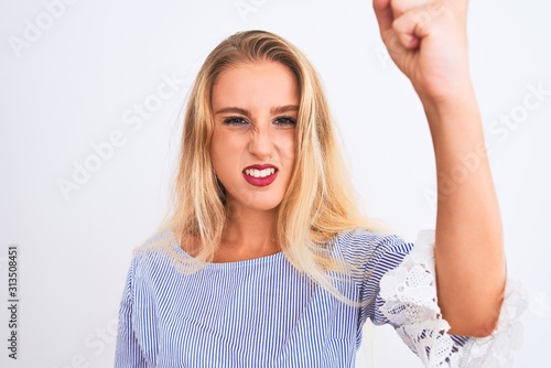 Young beautiful woman wearing elegant blue t-shirt standing over isolated white background annoyed and frustrated shouting with anger, crazy and yelling with raised hand, anger concept