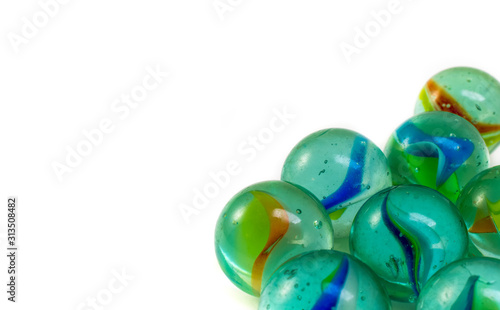 Glass marbles isolated on white background, close-up. Copy space for text. © Mehmet Gokhan Bayhan