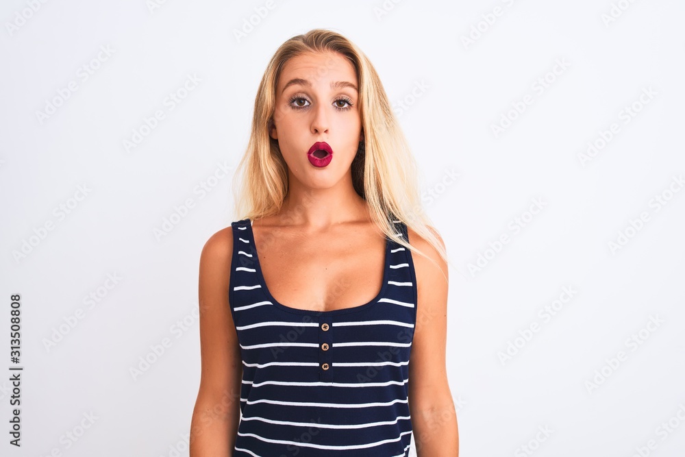 Young beautiful woman wearing casual striped t-shirt standing over isolated white background afraid and shocked with surprise expression, fear and excited face. Young beautiful woman wearing casual striped t-shirt standing over isolated white background afraid and shocked with surprise expression, fear and excited face.
