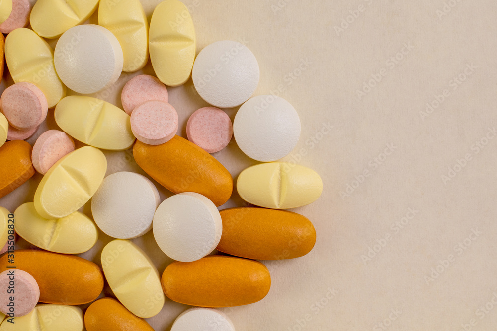 Pills close-up with copy space for text. Different colored medicine pills isolated on light color background. Pills close-up with copy space for text. Different colored medicine pills isolated on light color background.
