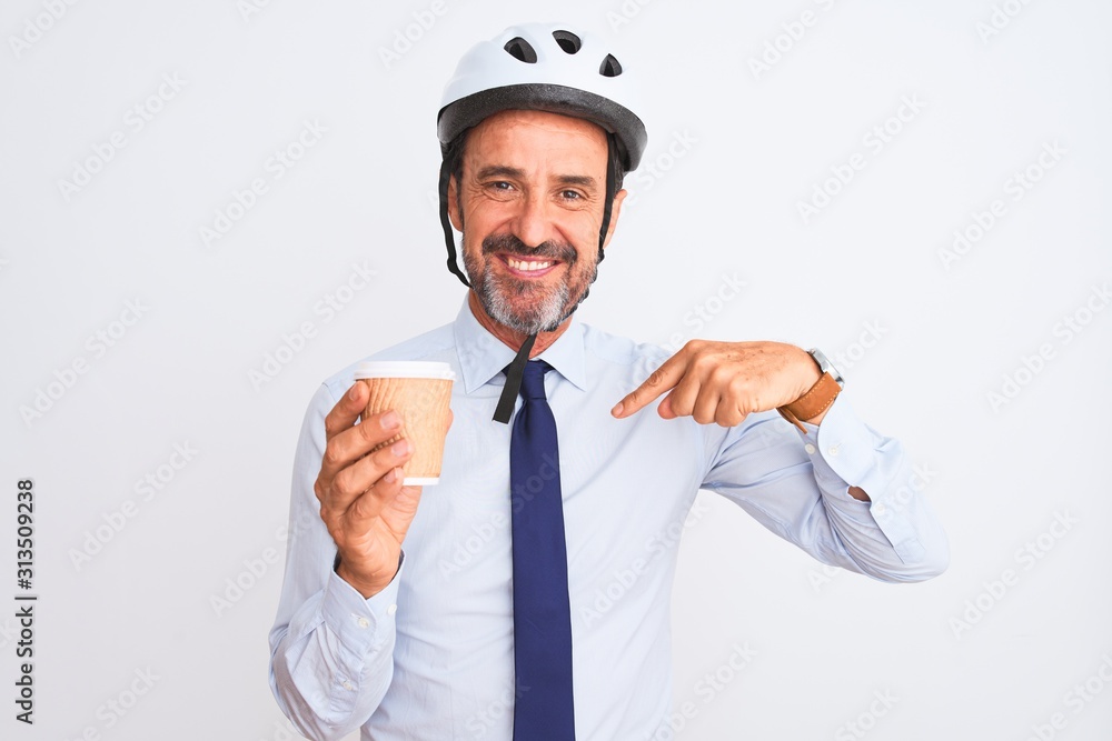 Middle age businessman wearing bike helmet drinking coffee over isolated white background with surprise face pointing finger to himself Middle age businessman wearing bike helmet drinking coffee over isolated white background with surprise face pointing finger to himself