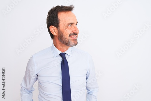 Middle age businessman wearing elegant tie standing over isolated white background looking away to side with smile on face, natural expression. Laughing confident.