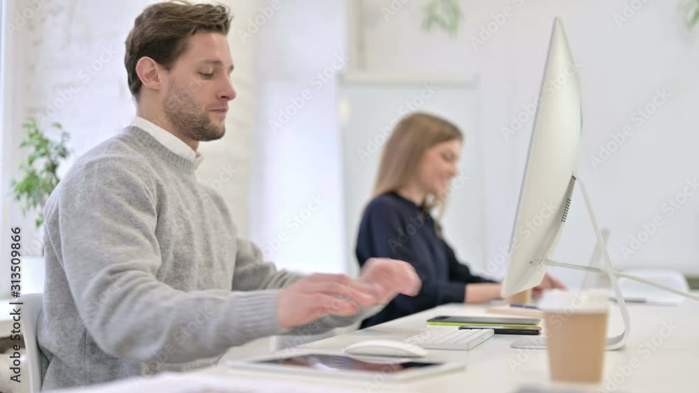 Attractive Creative Man Coming and Sitting at Office Desk Attractive Creative Man Coming and Sitting at Office Desk