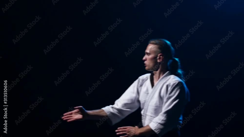 Aikido Master technique demonstration on black studio. Slow motion. Close up. Aikido Master technique demonstration on black studio. Slow motion. Close up.