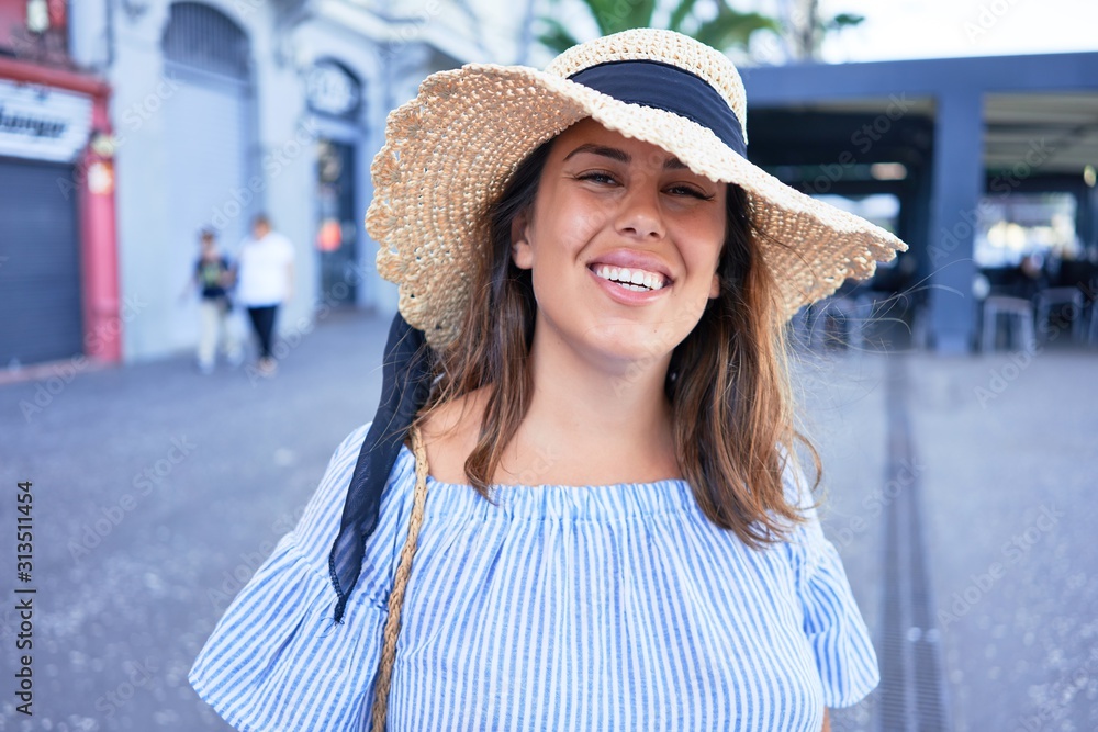 Young beautiful woman smiling happy walking on city streets on a sunny day of summer