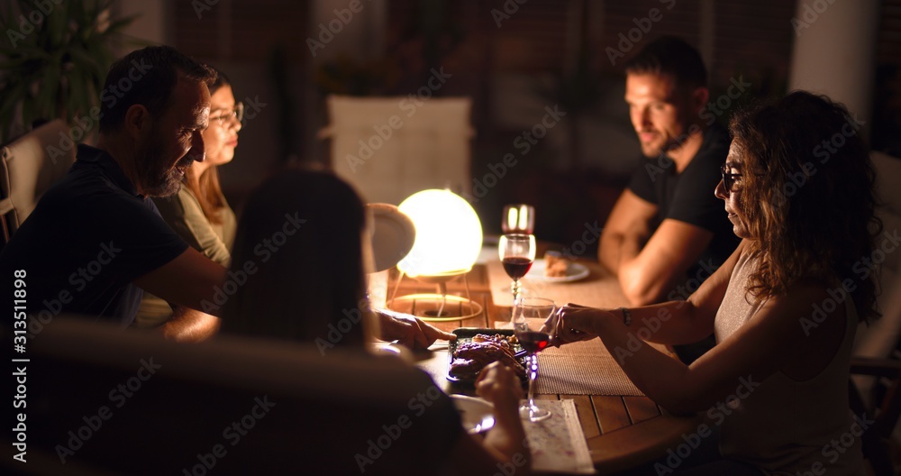 Beautiful family on dinner talking and smiling at terrace Beautiful family on dinner talking and smiling at terrace