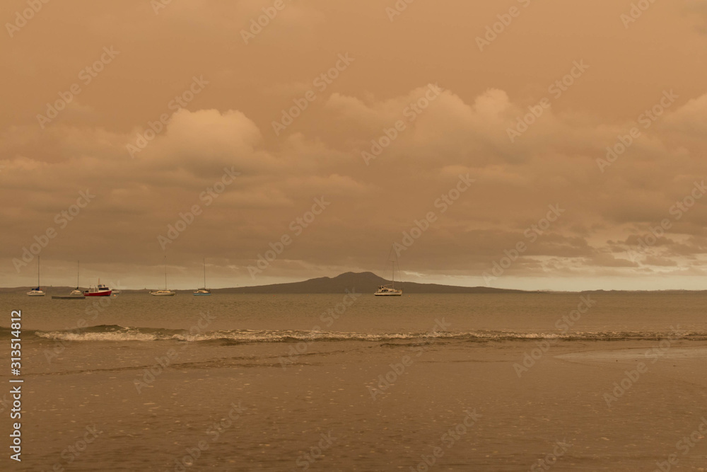 A haze from Australia's bushfires hangs over Torbay Beach, North Shore district of Auckland, New Zealand.