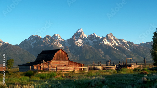 shot of a barn and grand teton at sunrise in wyoming