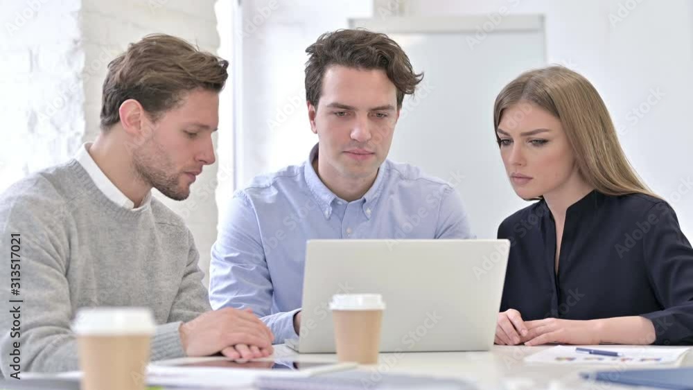 Young Creative Team Working on Laptop Together in Office Young Creative Team Working on Laptop Together in Office