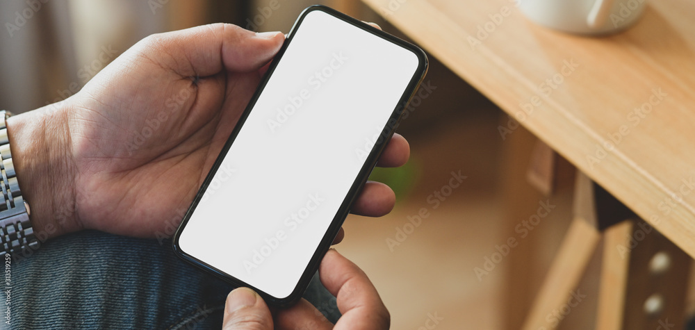 Cropped shot of young man holding blank screen smartphone Cropped shot of young man holding blank screen smartphone