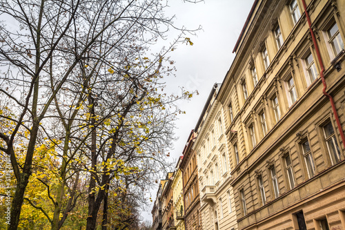 Facades in a typical street of Zizkov district in autumn, during a cloudy afternoon, with its traditional austro hungarian architecture and residential buildings photo