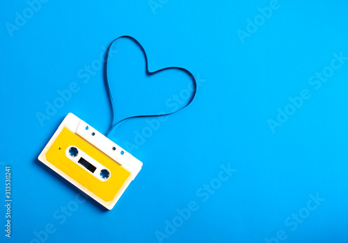 Fotografia Retro cassette tape with tape in the shape of heart on blue background