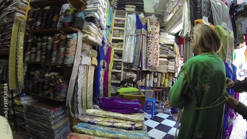 Mature woman trying on a green djellaba in store in Morocco. photo