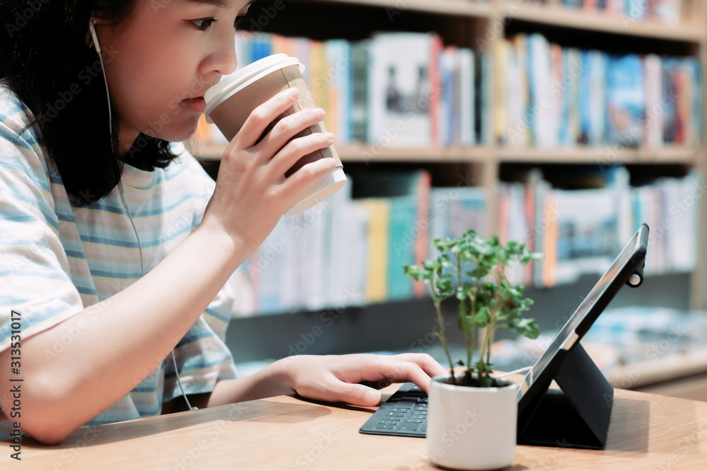 Asian working women drinking coffee and working in co working space Asian working women drinking coffee and working in co working space
