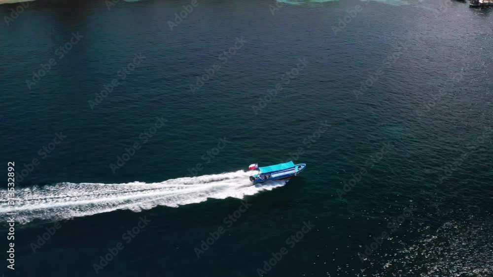Aerial, over ocean, pan right following small boat flying Texas flag, Roatan Aerial, over ocean, pan right following small boat flying Texas flag, Roatan