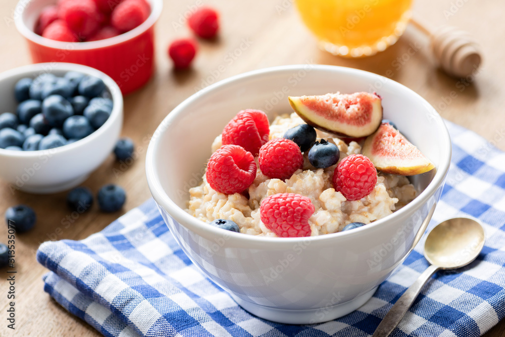 Tasty oatmeal with berries and fruits in a bowl. Healthy breakfast food concept Tasty oatmeal with berries and fruits in a bowl. Healthy breakfast food concept