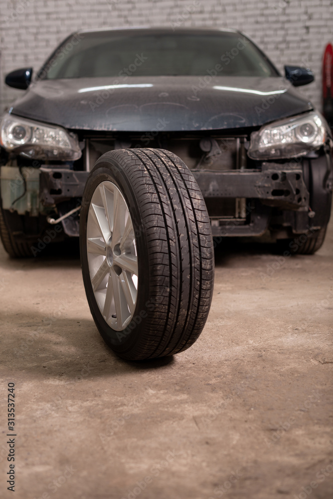 Photo of a car tire in the background of a car in the garage Photo of a car tire in the background of a car in the garage