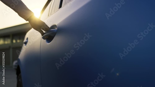 Hand of woman systems key unlock the car door before driving, Vehicle transportation travel of blue hatchback car on the street road. 4K UHD Cinematic footage