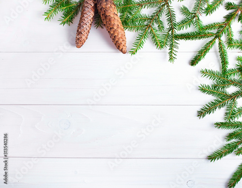 Christmas fir tree and fir cones on a white wooden background. Top view. Copy space.