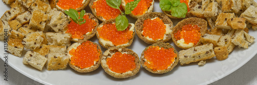 Sandwiches with red caviar on white plate close up. panoramic shoot