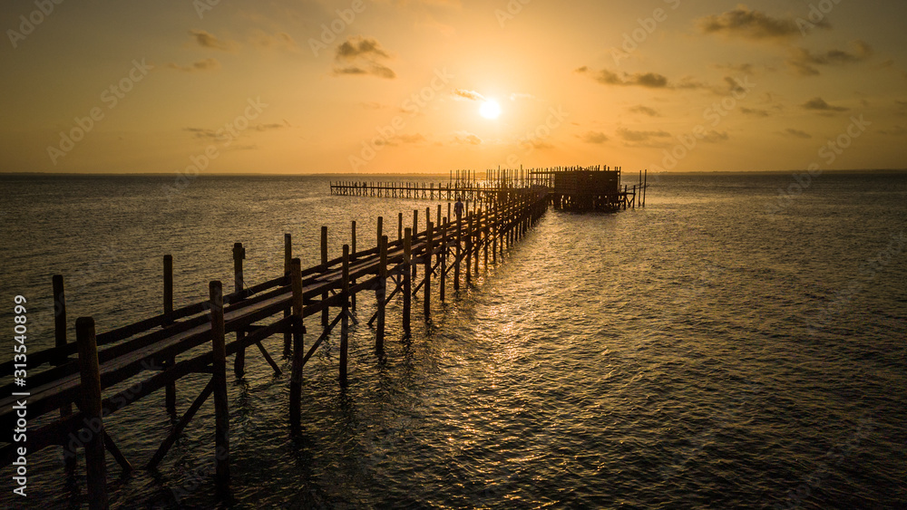 Sunset over a long dock (pier) in the ocean in Zanzibar, Tanzania