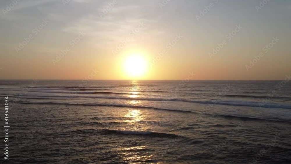 Tropical beach on Uluwatu on sea water surface at sunset, aerial video, drone point of view, drone flying above the sea surface. Tropical beach on Uluwatu on sea water surface at sunset, aerial video, drone point of view, drone flying above the sea surface.