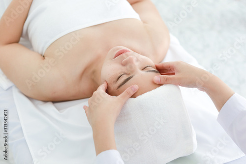 Asian young woman getting spa treatment at beauty salon. spa face massage. facial beauty treatment