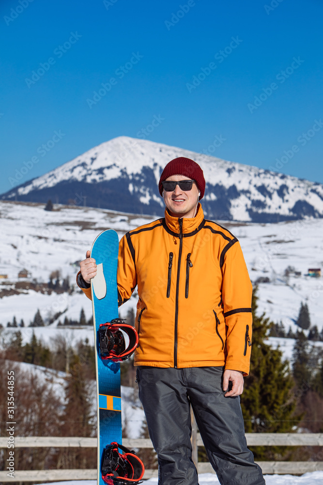 man in sunglasses holding snowboard