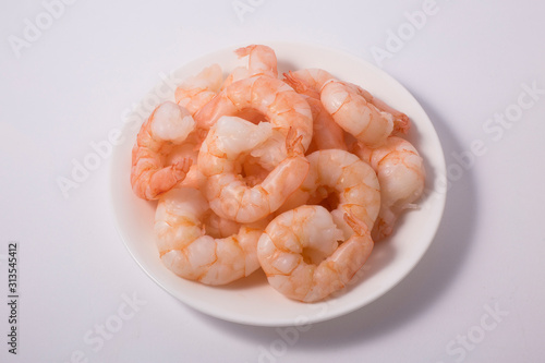 Top view of bowl with boiled peeled shrimps isolated on white