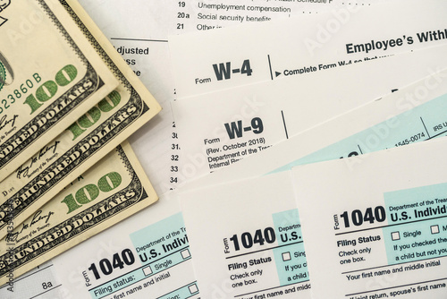 US tax form w4  w9 with money. © RomanR