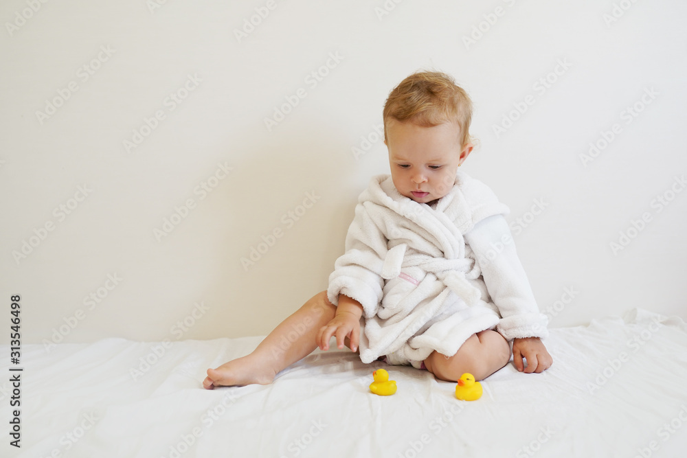 Beautiful baby after a bath plays with rubber ducks with a copy space Beautiful baby after a bath plays with rubber ducks with a copy space