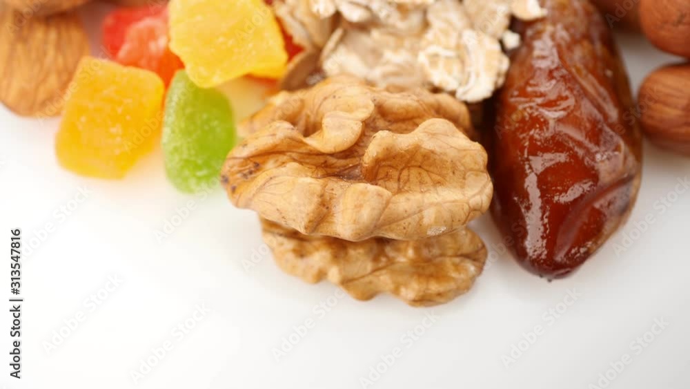 Healthy eating concept. Granola. Dried fruits: nuts, raisins, cashews, dried apricots, hazelnuts, pumpkin seeds. Сircular motion Healthy eating concept. Granola. Dried fruits: nuts, raisins, cashews, dried apricots, hazelnuts, pumpkin seeds. Сircular motion