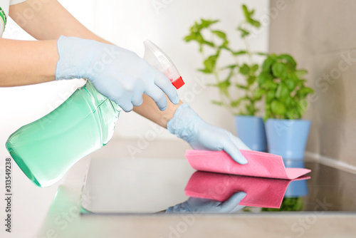 Woman in gloves cleaning kitchen. © Tomasz Warszewski