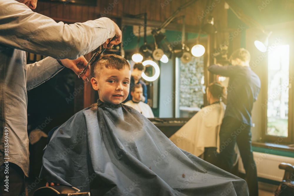 The child is being cut hairstyles - obrazy, fototapety, plakaty 