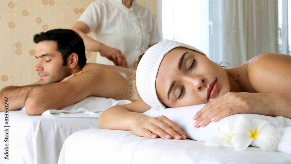 Couple enjoying body massage at spa club.woman relaxing with sleep on massage table. Couple enjoying body massage at spa club.woman relaxing with sleep on massage table.