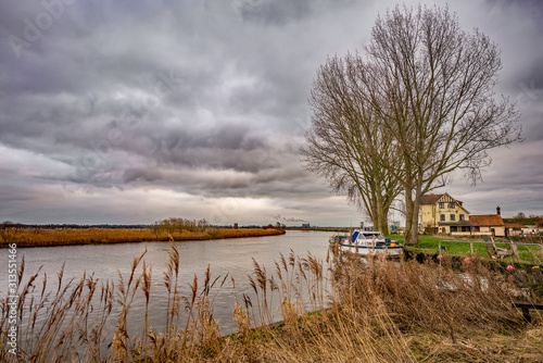 The Beauchamp Arms pub on the bank of the River Yare on the Norfolk Broads captured on a dull, grey and overcast winter's day photo