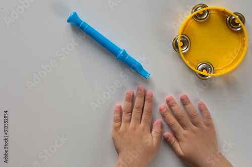 Top view of tambourine, pipe and child hands on the white background photo