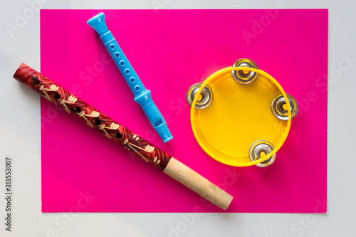 Top view of tambourine and two pipes on the pink background photo